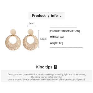Detail view of large gold hollow round earrings showing 5cm by 6.8cm size and iron texture