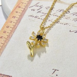 Macro detail of sunflower pendant with black center and clear crystal petals