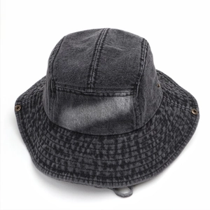 Détail d'un chapeau bob en denim gris délavé avec coutures renforcées et cordon réglable