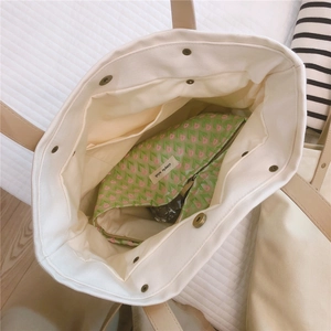 Detail view of large white canvas tote interior with floral pocket and magnetic closure