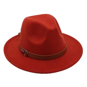 Detail of red wool felt fedora with a brown leather strap and silver metal buckle