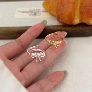 Macro shot of silver and gold bow rings with S925 hallmark on adjustable band