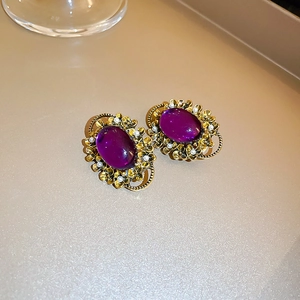 Detail of vintage French gold flower ear clip with purple oval stone and pearls