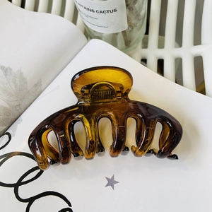 Detail of amber translucent flower hair claw clip with smooth resin finish and strong spring
