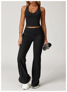 Detail view of black yoga tank top with high-waist flared pants on model in studio