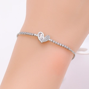 Detailed view of silver heart pendant with pear-cut zircon and adjustable pave-set bracelet