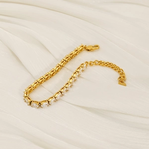 Bracelet tennis doré élégant avec zircons blancs ovales sur tissu satiné blanc
