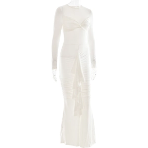 Détail de robe blanche à manches longues avec plis croisés et ourlet à volants