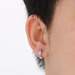 Close-up of silver heart-shaped hoop earrings with crystal pavé on a model's ear