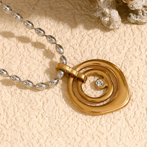 Detail of 18K gold double oval pendant with crystal on silver bead chain necklace