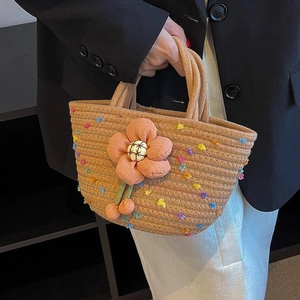 Handwoven camel cotton rope handbag featuring colorful pompoms and large fabric flower detail