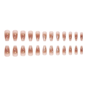 Press-on nails featuring nude pink gradient and golden heart patterns in coffin shape