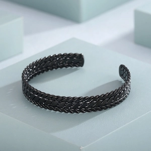 Close-up of black braided stainless steel cuff bracelet with textured wheat ear pattern