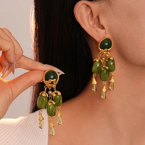 Boucles d'oreilles rétro en résine vert olive de style doré sur modèle