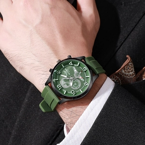 Detail of green quartz sports watch with silicone strap worn on male model wrist