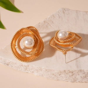 Vintage golden spiral flower pearl stud earrings on a natural white stone base