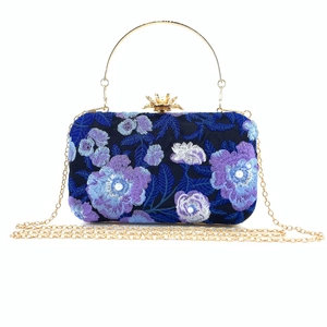 Detail of navy embroidery clutch bag with floral pearls and golden crown clasp