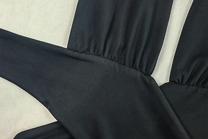 Close-up of ruched pleats and texture on the black slim-fit bodycon halter dress