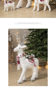 Detailed view of plush white Christmas reindeer decoration with festive red scarf and saddle