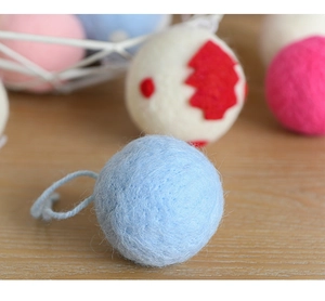Close-up of wool felt Christmas ornaments in assorted colors on a rustic wooden surface