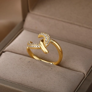 Macro detail of gold-plated twisted ring with pavé-set zircons in a brown jewelry box