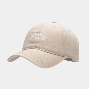 Dettaglio del cappellino beige in cotone con ricamo Aquiver bianco e logo montagna