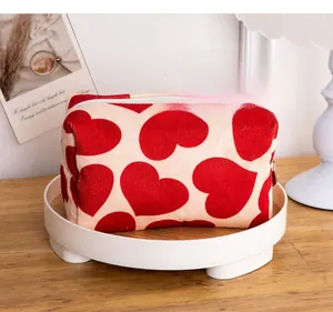 Macro shot of large capacity corduroy makeup bag with red heart pattern and metal zipper