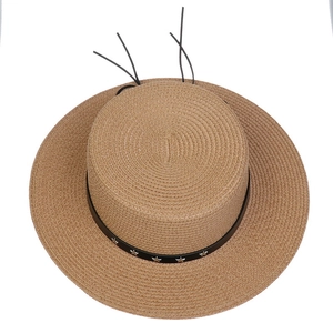 Top view of khaki straw hat with flat top and black leather star-studded band