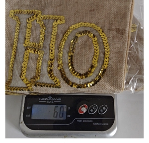 Close-up of a Christmas stocking gift bag with gold sequin letter embroidery