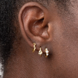 Three-piece gold hoop earring set with twisted crystals and knot designs on model