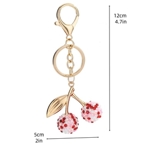 Détail du porte-clés cerise dorée avec les dimensions indiquées : 12cm de long et 5cm de large