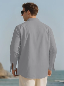 Back view of a grey long-sleeve linen shirt for men in a scenic outdoor seaside setting