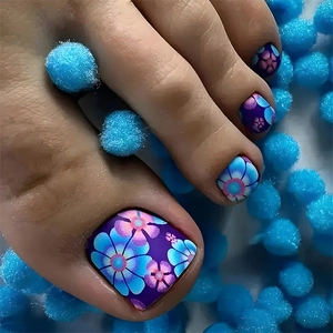 Macro view of blue and purple floral toe nail stickers on soft blue pom-poms background