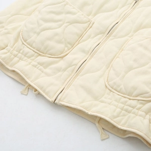 Detail of cream quilted jacket with zipper, large pockets and adjustable drawstring hem