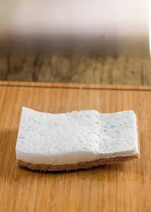 Macro shot of dual-layer wood pulp sponge and coarse scouring fiber on bamboo surface