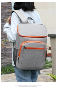 Outdoor insulated grey backpack with orange zipper details and side mesh pockets