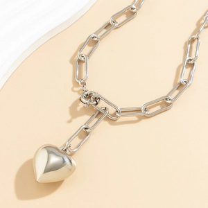 Close-up of silver heart pendant with paperclip chain and round toggle clasp closure