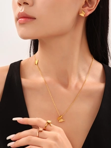 Detailed close-up of 18K gold butterfly jewelry set including necklace, rings, and earrings