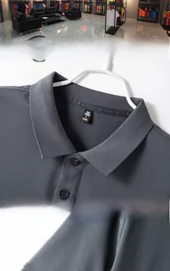 Close-up of charcoal grey polo shirt neckline with three buttons and detailed collar label