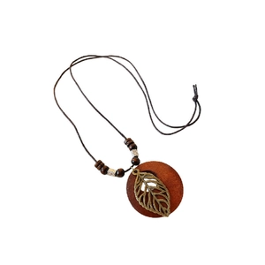Bohemian style necklace with leaf pendant and wood beads on minimalist white background