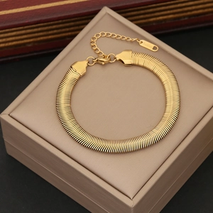 Close-up of golden herringbone chain bracelet with adjustable clasp on premium display box