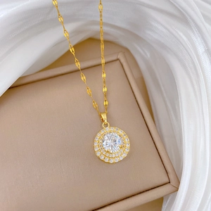 Close-up of golden necklace with a luxury round pavé diamond pendant on a velvet box