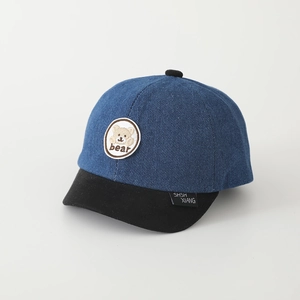 Dettaglio del ricamo dell'orso e della tesa corta su questo cappellino in denim