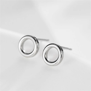 Detailed macro view of silver hollow circular stud earrings in polished stainless steel