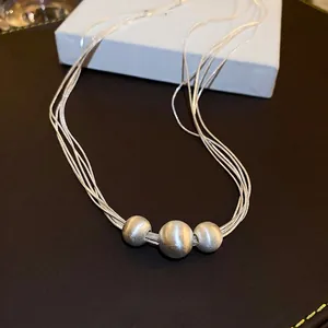 Elegante silberne mehrlagige Halskette mit drei mattierten Perlen auf strukturiertem Grund