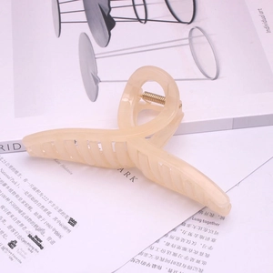 Minimalist beige large hair claw clip in a twisted geometric design with gold metal spring