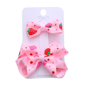 Handmade pink strawberry hair clips for kids on a professional display card