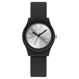 Détail macro du cadran argenté avec bracelet en silicone noir d'une montre à quartz