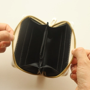 Internal structure of small cream canvas wallet featuring card slots and zipper pocket