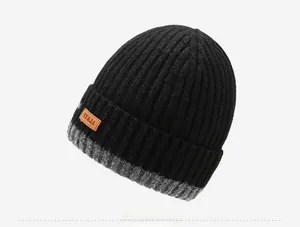 Detail of men's winter knit beanie showing ribbed texture and orange leather logo patch